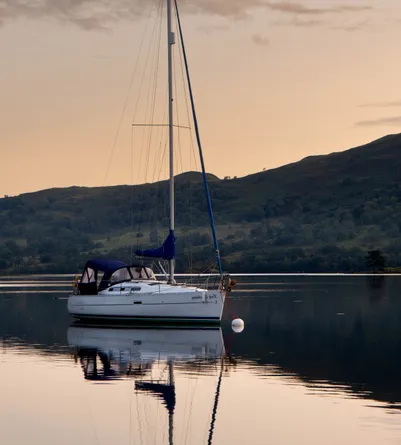 A small sailing boat on the lake at dusk